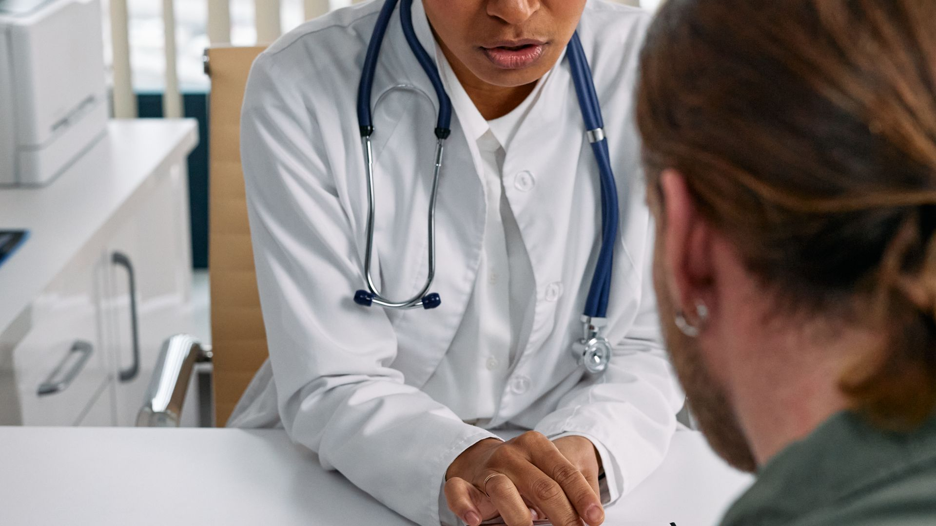 Médica atendendo paciente em consultório